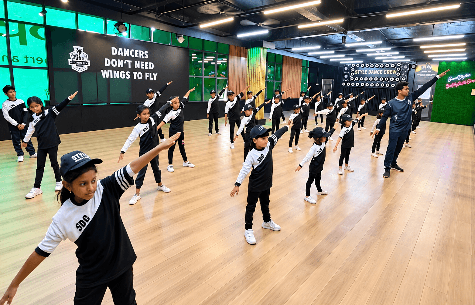 SDC students rehearsing in rows on the studio's wooden floor, Shivamogga